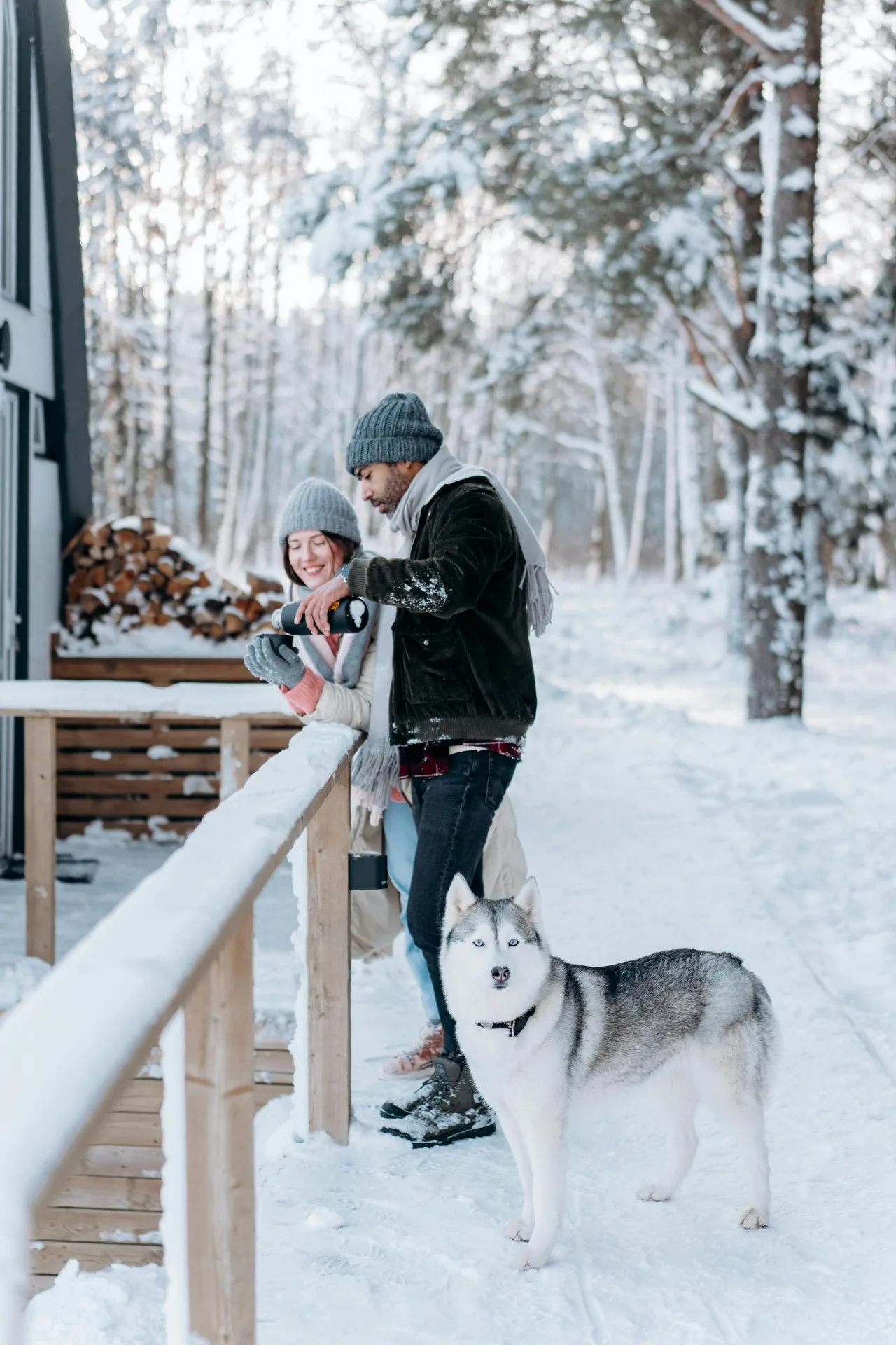 Casal feliz com husky na neve canadense